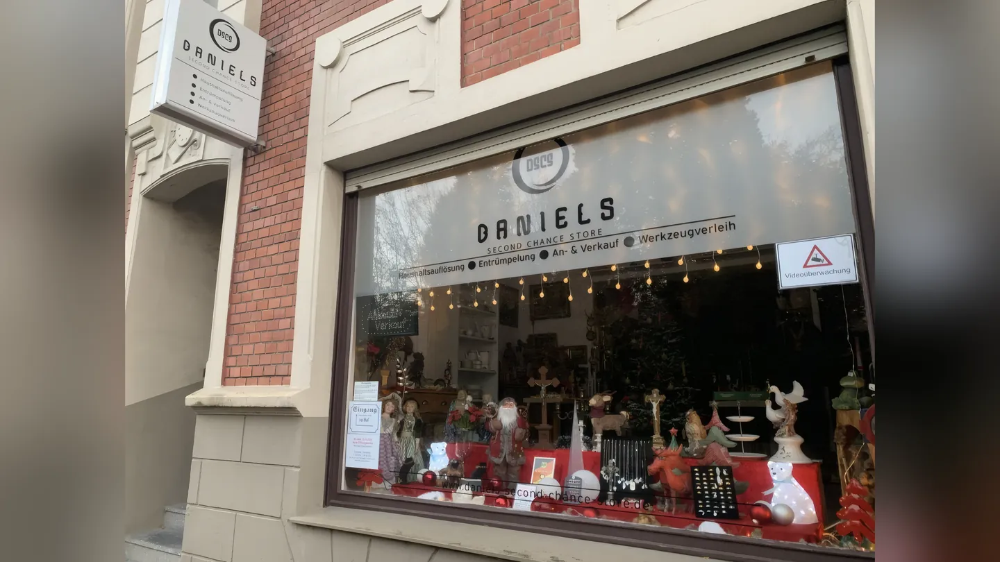 Schaufenster von Daniels Second Chance Store mit Beschriftung auf der Scheibe und einem Ausleger-Schild an der Fassade.